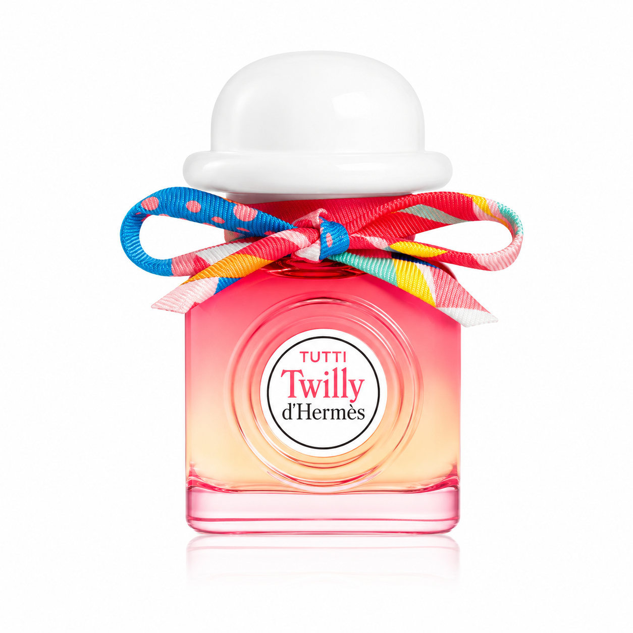 Hermès Tutti Twilly d'Hermès Eau de Parfum perfume bottle isolated on a white background, featuring a vibrant pink-to-peach gradient glass bottle with a rounded white cap and a colorful silk Twilly ribbon tied around the neck.