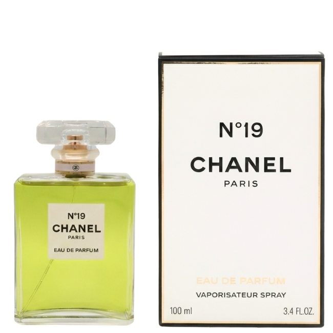 Chanel N°19 Eau de Parfum 100ml bottle with its vibrant green liquid and classic clear glass design, standing next to its minimalist white and black packaging.
